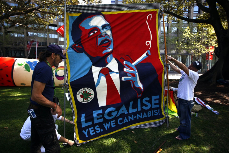 Members of the Help End Marijuana Prohibition (HEMP) Party lift a banner displaying a parody of U.S. President Barack Obama