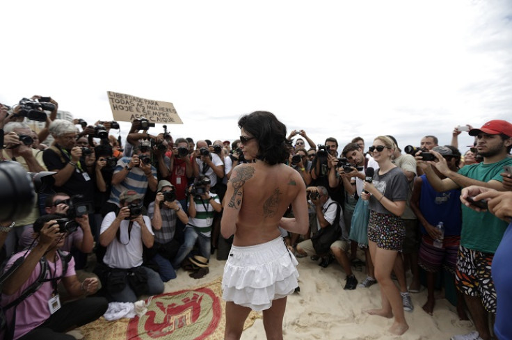 A topless protester poses in front of photographers on Brazil's Ipanema beach.
