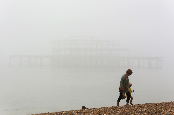 A woman and child walk on the beach in Brighton, UK.