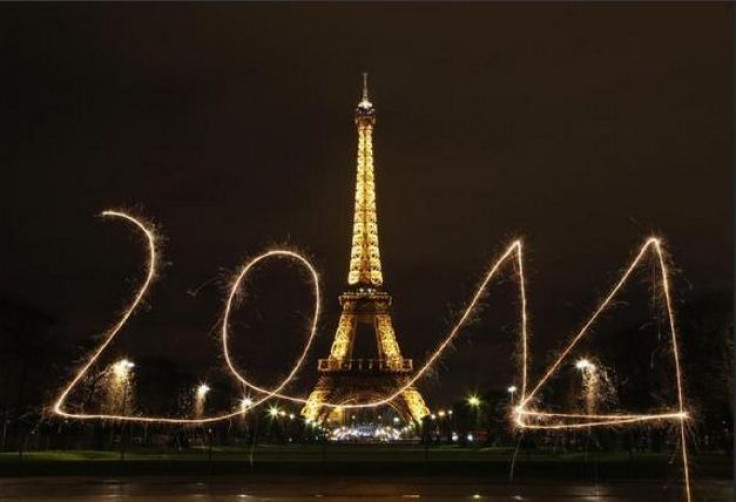 A reveler writes "2014" with sparklers in front of the Eiffel Tower in Paris.