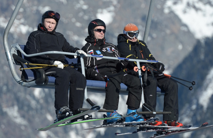 Russian President Vladimir Putin (L) and Prime Minister Dmitry Medvedev (C) sit on a chair lift during their visit to the "Laura" cross country ski and biathlon centre in the resort of Krasnaya Polyana near Sochi January 3, 2014.