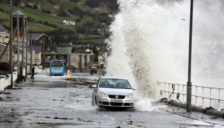 Waves crash against the coastal wall in the village of Carnlough as high tides and strong winds cause some flooding in coastal areas of Northern Ireland