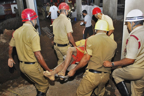 Rescuers carry an injured man away from the wreckage of Saturday's building collapse in Goa.