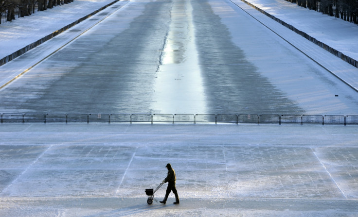 A National Park Service worker spreads salt on the steps of the Lincoln Memorial in Washington, USA.