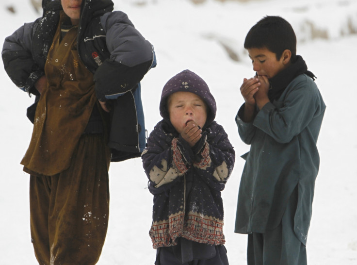 Children stand in the snow outside their shelter in Kabul, Afghanistan.