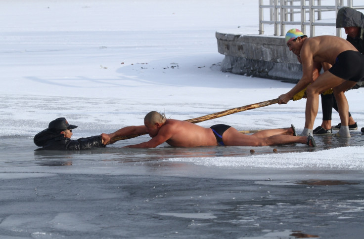 Winter swimmers try to pull an elderly man out of icy waters after he was trapped in a partially frozen lake at a park in Changchun, China.