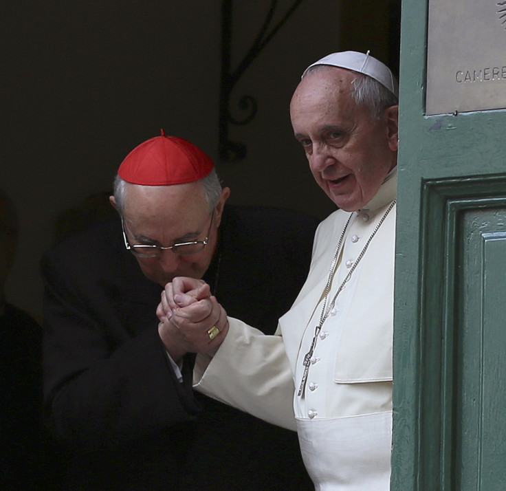 Cardinal Agostino Vallini kisses the hand of Pope Francis as he leaves at the end of his mass at the Church of the Most Holy Name of Jesus in Rome