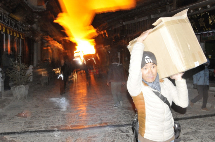 A man carrying his belongings, runs away from a fire at the Dukezong Ancient Town in Shangri-la county.