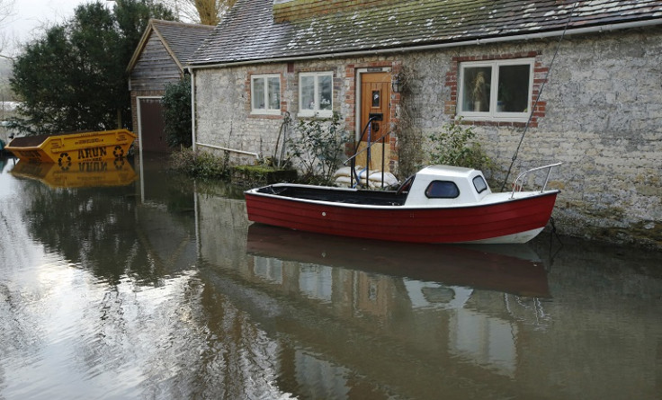 A boat floats in front of a house during flooding at Bury near Pulborough in southern England