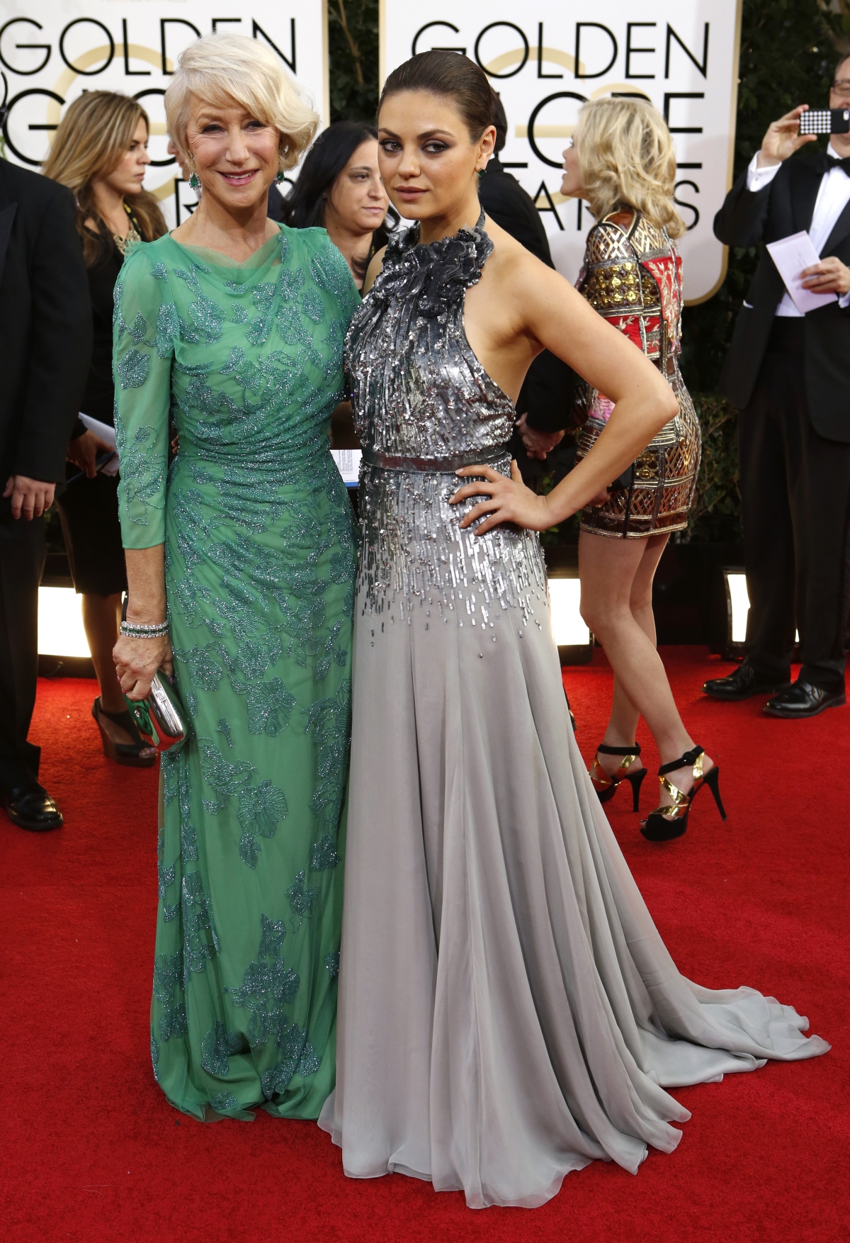 Actresses Helen Mirren L and Mila Kunis pose on the red carpet of Golden Globes.