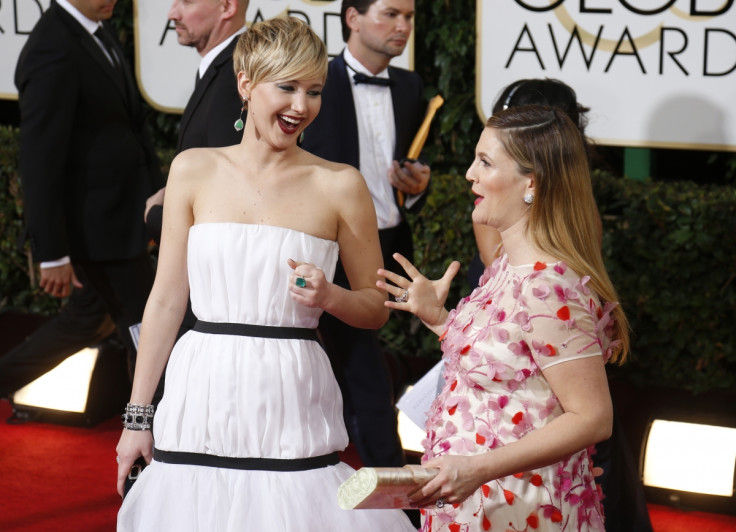 Actresses Jennifer Lawrence and Drew Barrymore arrive at the 71st annual Golden Globe Awards