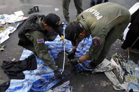 Policeman examine the scene of Sunday's explosion at an anti-government protest in Bangkok.