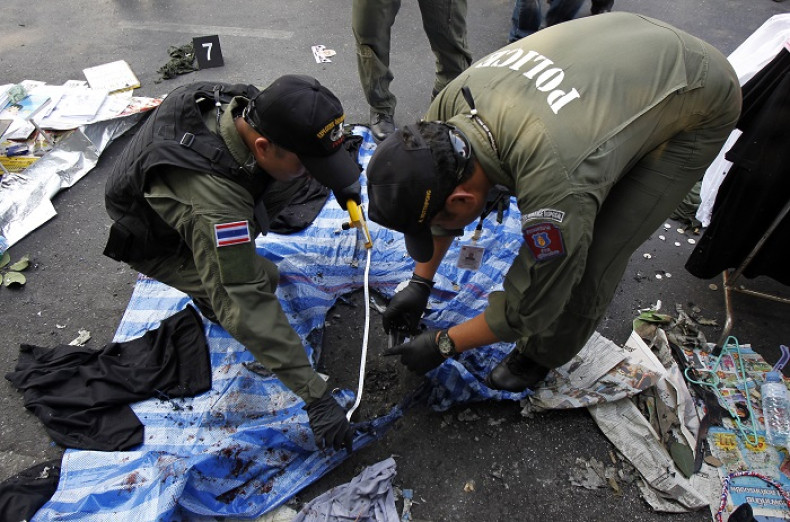 Policeman examine the scene of Sunday's explosion at an anti-government protest in Bangkok.