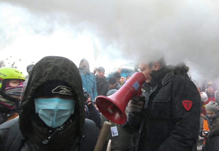 Vitaly KIitschko grimaces as police target him with powder spray during his address to crowds in Kiev