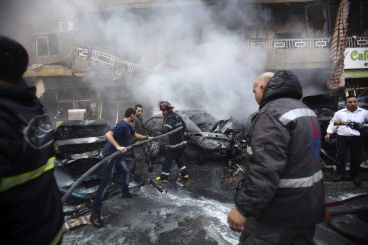 Firefighters extinguish a fire at the site of an explosion in the Haret Hreik area,