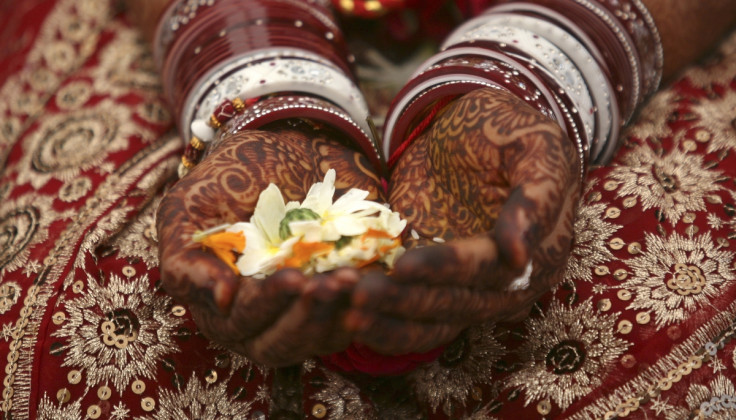 A bride holds flowers with her hands decorated with henna paste during her wedding ceremony in the western Indian city of Ahmedabad.