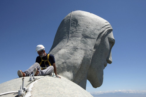 Don't look down: A worker sits on arm of the Christ the Redeemer statue in Rio de Janeiro, which was hit by lightning Don't look down: A worker sits on arm of the Christ the Redeemer statue in Rio de Janeiro, which was hit by lightning