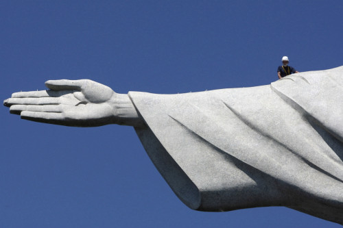 Repair man is dwarfed by huge scale of Christ the Redeemer statue in Rio de Janeiro Repair man is dwarfed by huge scale of Christ the Redeemer statue in Rio de Janeiro