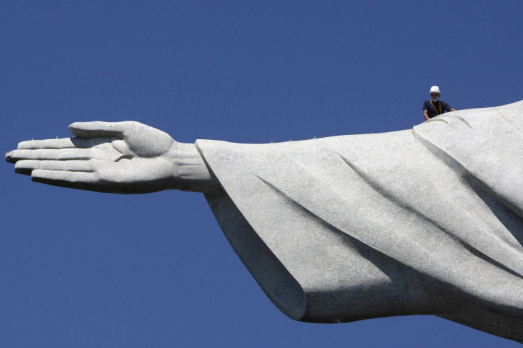 Repair man is dwarfed by huge scale of Christ the Redeemer statue in Rio de Janeiro