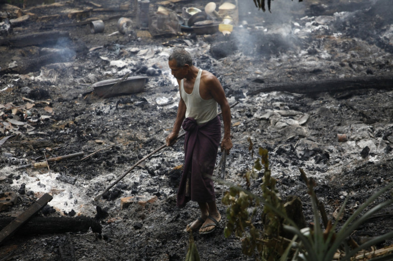 A Muslim man searches for his belongings left behind of his burnt home at Thapyuchai village, outside of Thandwe in the Rakhine state