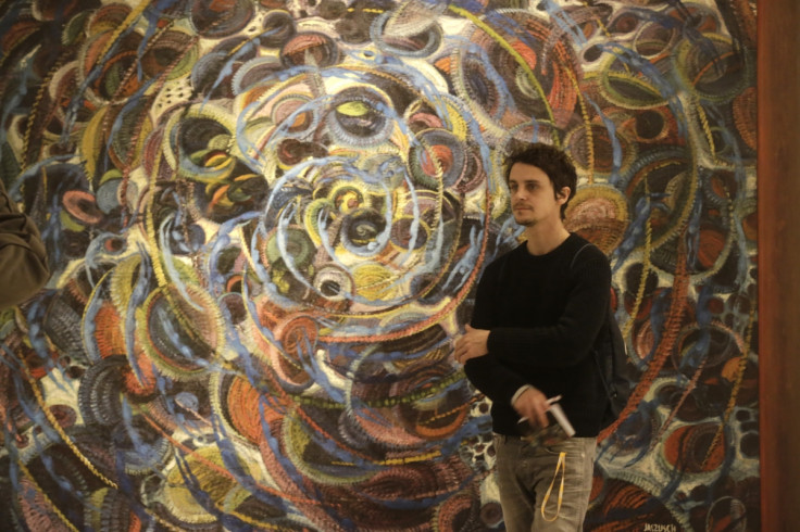 A man walks past painting "Circulation of Life - Pilgrim Souls" by Slovakian painter Anton Jasusch