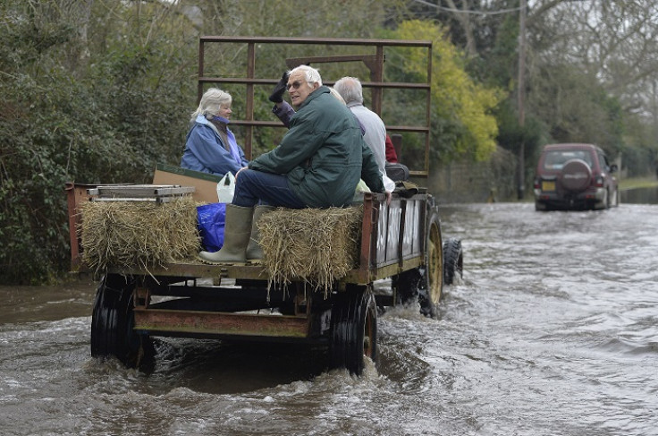 Residents are driven through flooded parts of southwest England on a tractor.
