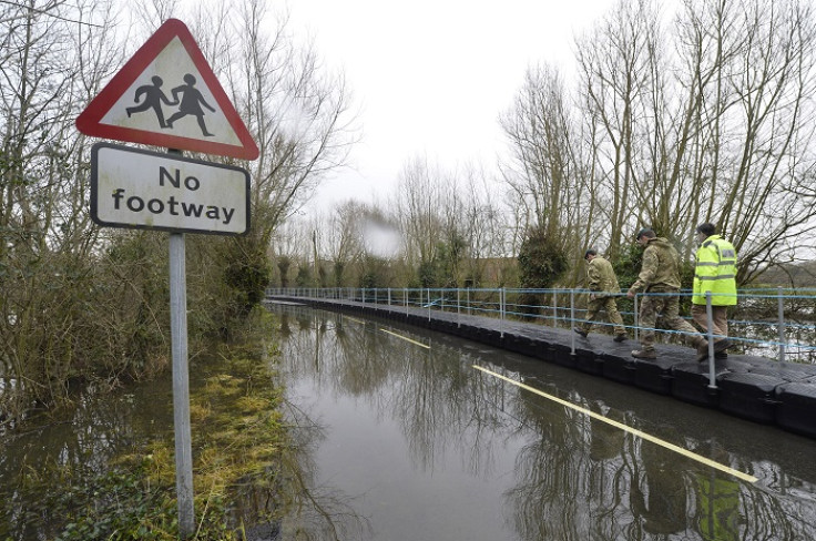 British Army Royal Engineers walk along a floating pontoon in flooded parts of Somerset.