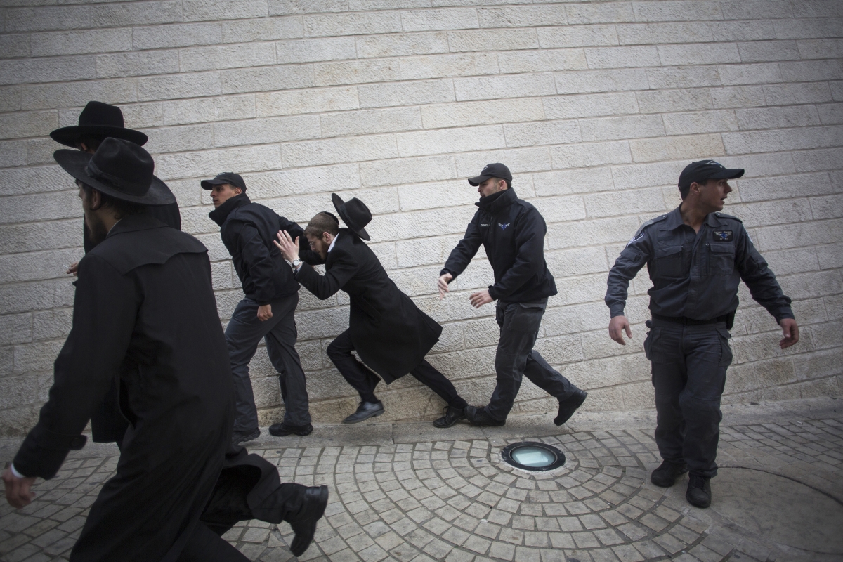 An Israeli policeman pushes an ultra-Orthodox Jewish protester during a demonstration in Jerusalem