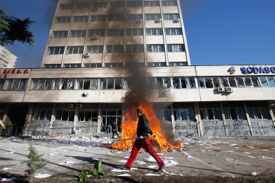 A Bosnian protester walks by a local government building A Bosnian protester walks by a local government building