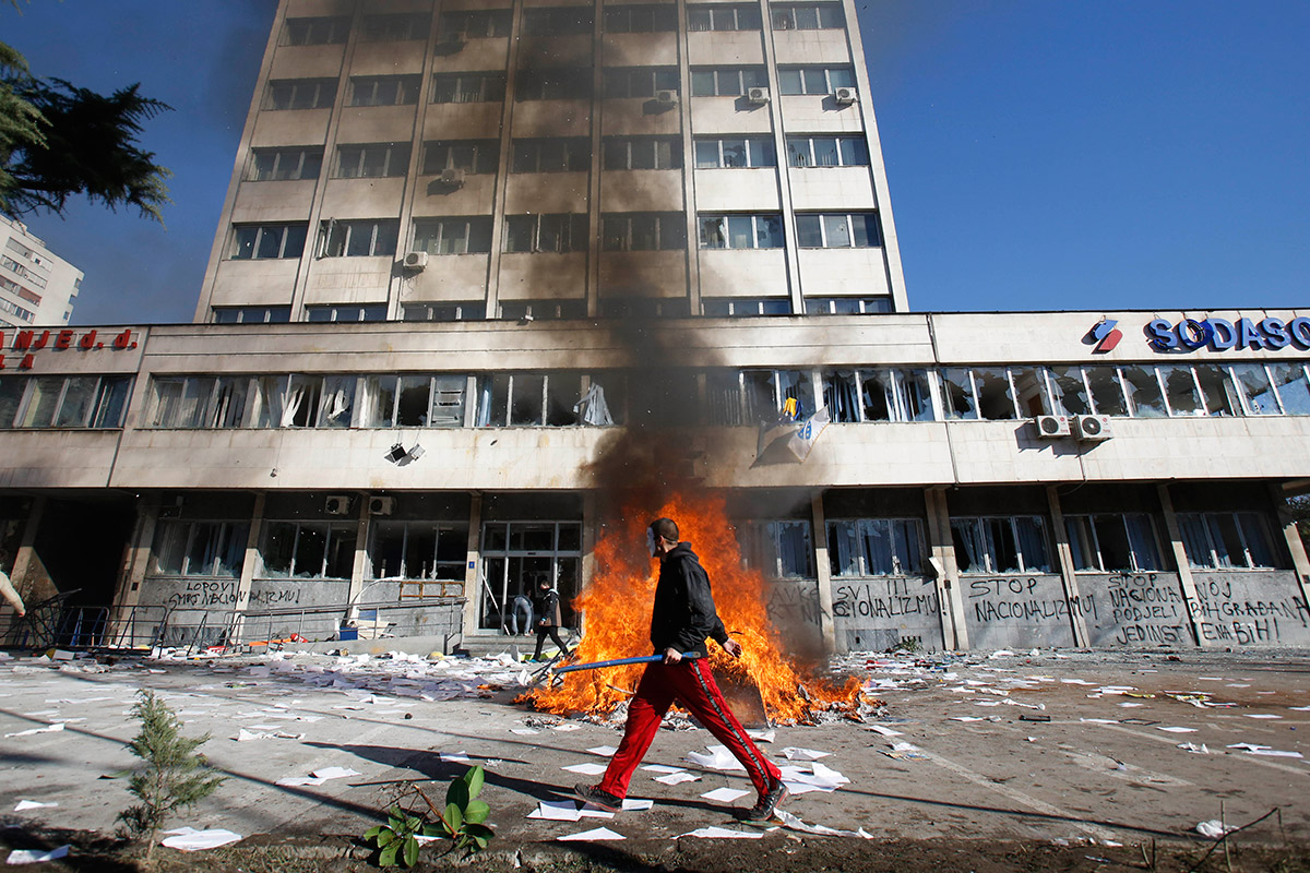 A Bosnian protester walks by a local government building