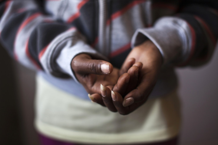 Hrity, a migrant from Eritrea, holds her hands as she poses for a photograph in the central city of Lod, near Tel Aviv