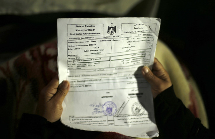 Suhad al-Katib, a Palestinian woman patient who suffers cancer holds paperwork inside her house after she was not allowed to enter Israel, in Gaza