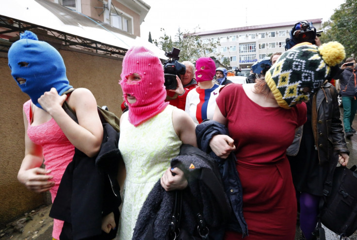 Masked members of protest band Pussy Riot leave a police station in Adler during the 2014 Sochi Winter Olympics