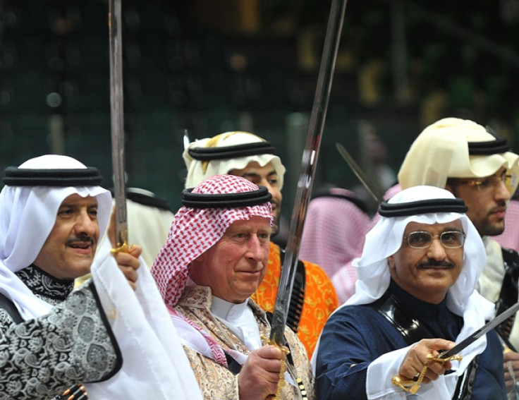 Britain's Prince Charles (C), wearing a traditional Saudi uniform, dances with a sword