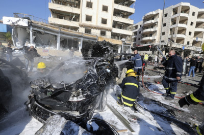 Civil defence members put out a fire at the site of an explosion in the southern suburbs of Beirut