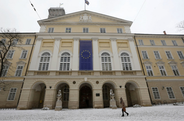 A woman walks past a building with a European Union flag in the western Ukranian city of Lviv