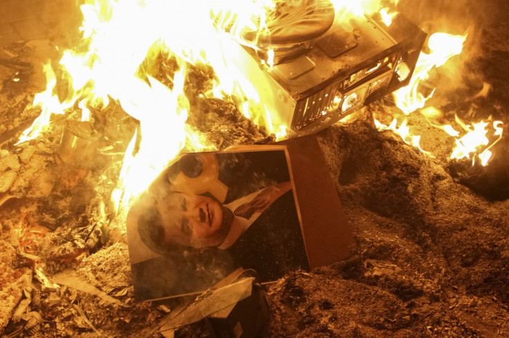 A portrait of Ukrainian President Viktor Yanukovich burns near the destroyed building of the security service in Lviv