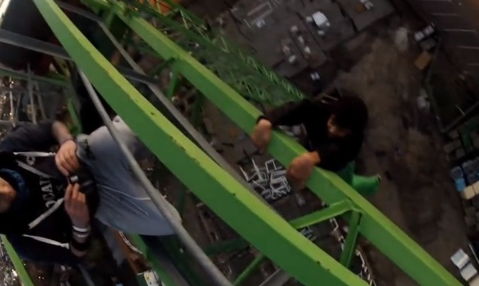 Youngster hangs from crane arm (right) while fellow free-climber films stunt in Sutton, south London