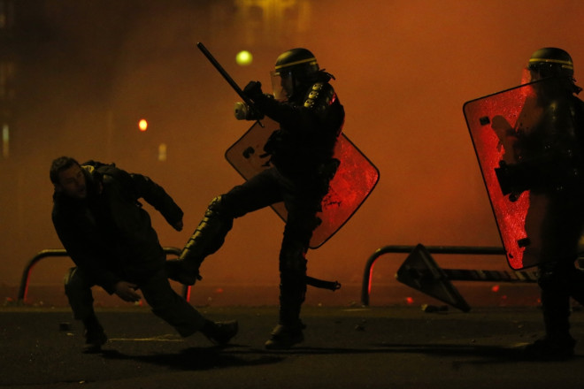 A protester is kicked by a French riot policeman during clashes A protester is kicked by a French riot policeman during clashes