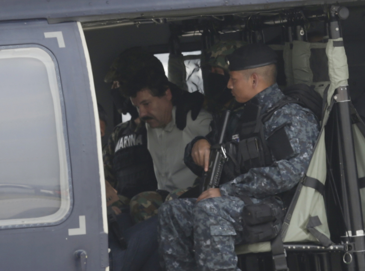 Guzman is seated on a federal police helicopter, ready to be transported to a high security detention facility. Guzman is seated on a federal police helicopter, ready to be transported to a high security detention facility.