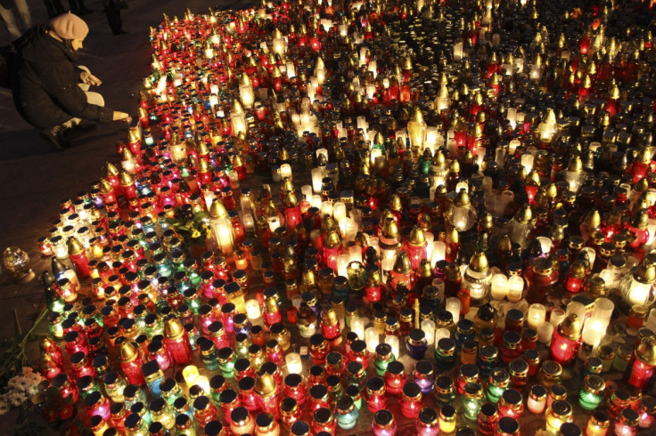 A woman lights a candle to pay her respects to fallen anti-Yanukovich protesters in central Lviv