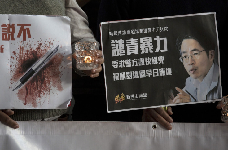Pro-democracy activists hold a sign with an image of former chief editor of the Ming Pao daily Kevin Lau Chun-to as they attend a candlelight vigil to urge the police to solve the stabbing incident involving Lau