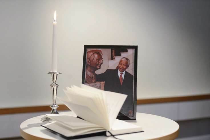 A condolence book is seen together with a photograph of late South African President Nelson Mandela posing beside the statue of former Social Democratic Party leader Olof Palme