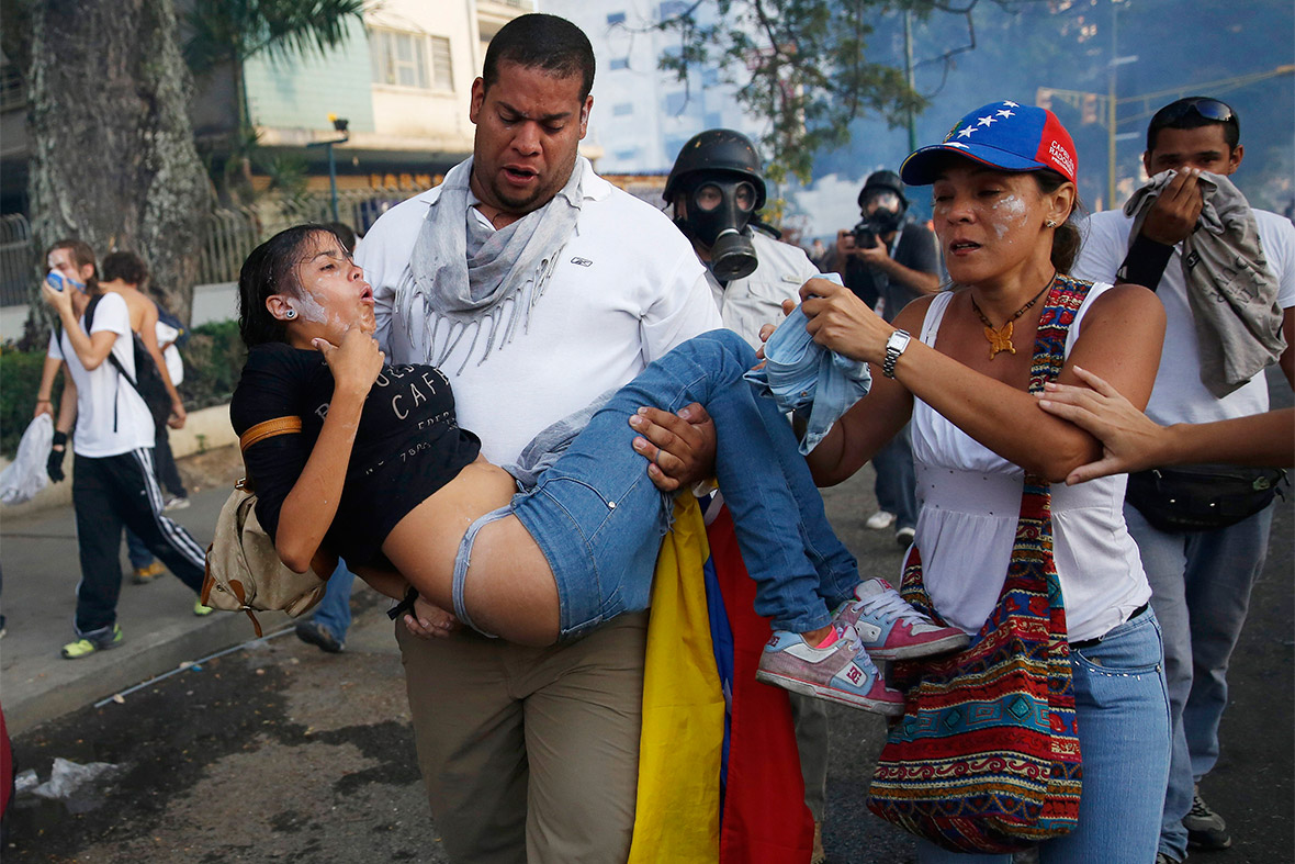 Demonstrators help a girl overcome by tear gas in Caracas. 