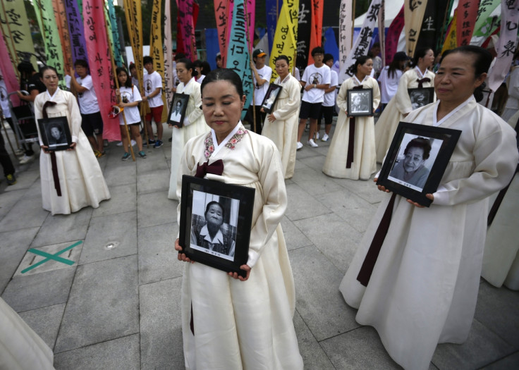 Participants carry the portraits of Korean women who were made sex slaves by the Japanese military during World War II