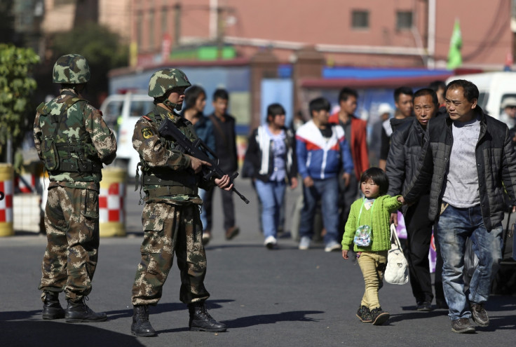 Paramilitary policemen patrol the streets after a knife attack at Kunming railway station, Yunnan province