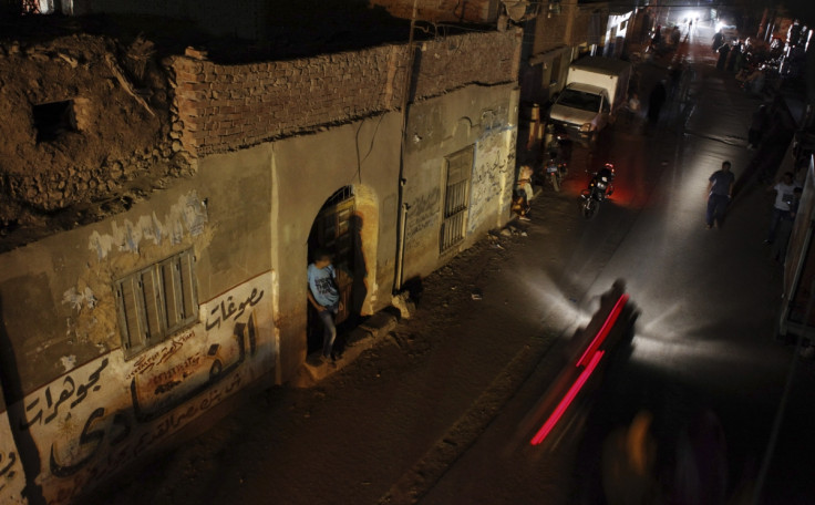 People and vehicles are seen during a power cut in Toukh, El-Kalubia governorate, about 25 km (16 miles) northeast of Cairo May 26, 2013.