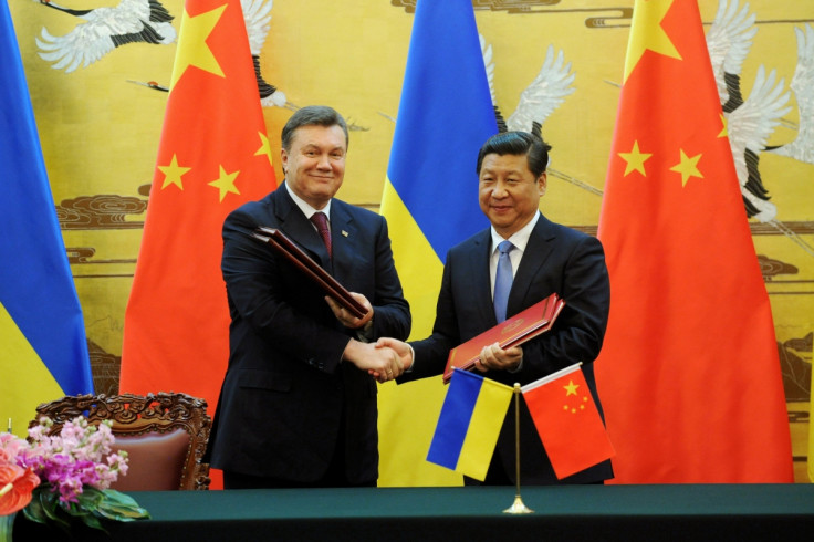 Ukraine's ousted President Viktor Yanukovich (L) shakes hands with Chinese President Xi Jinping