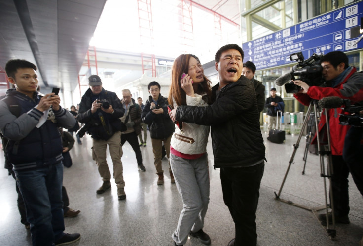 A relative (woman in white) of a passenger onboard Malaysia Airlines flight MH370 cries as she talks on her mobile phone at the Beijing Capital International Airport in Beijing March 8, 2014.