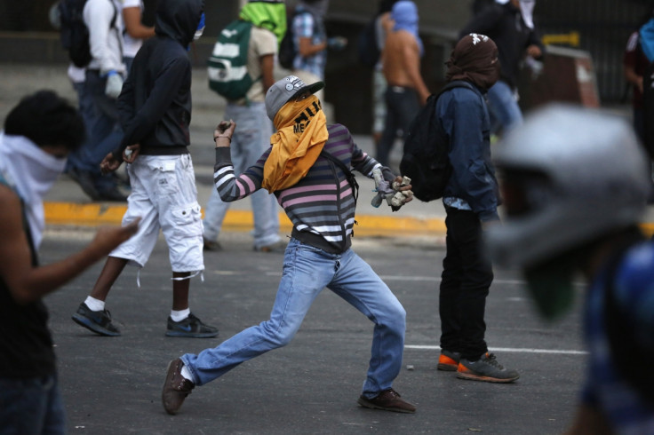 Anti-government protesters throw stones during a protest against Nicolas Maduro's government in Caracas March 7